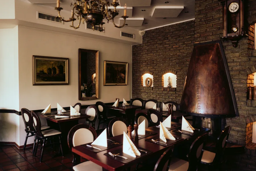 Gastraum des Restaurant Hermes mit Kupferkamin und Kronleuchter